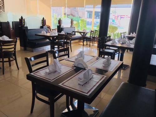 a restaurant with tables and chairs with napkins on them at Daraysh Hotel in Sharjah