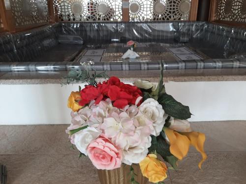 a vase with a bouquet of flowers at Daraysh Hotel in Sharjah