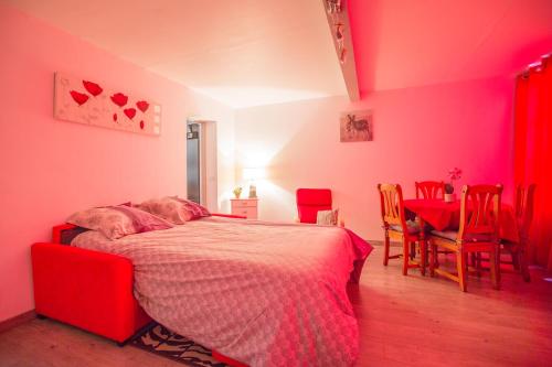 une chambre avec un lit et une table avec des chaises dans l'établissement Appart Coeur de Rouen - Place des Carmes, à Rouen