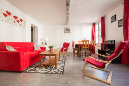 - un salon avec un canapé et des fauteuils rouges dans l'établissement Appart Coeur de Rouen - Place des Carmes, à Rouen