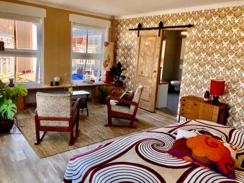 a bedroom with a bed and a desk and chairs at Ruime studio 'In de drie koningen' in hartje Middelburg in Middelburg