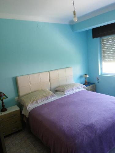 een blauwe slaapkamer met een groot bed met paarse lakens bij Casa pantin in Valdoviño