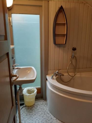 a bathroom with a sink and a tub and a mirror at Chalet Joran & Naomi in Barvaux