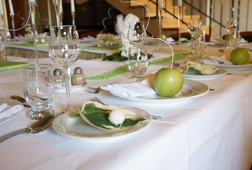 uma mesa com pratos de comida e copos de vinho em Hotel Grodzki em Poznań