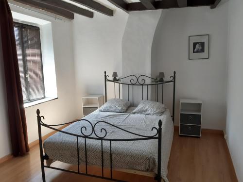 a bedroom with a black bed in a white room at Ferme Des Chapelles in Fresnes-en-Tardenois