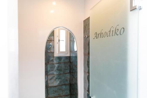 a hallway with an arched doorway and a mirror at Arhontiko in Naxos Chora
