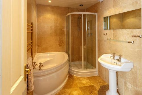 a bathroom with a tub and a sink and a shower at Durham House Holiday Let, sleeps 26 with Croft and Hay Loft in Sedgefield