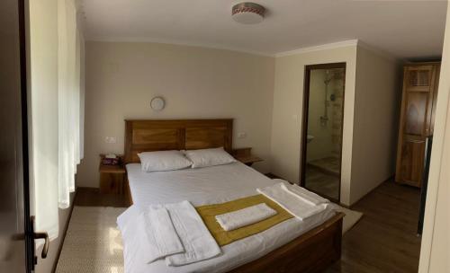 a bedroom with a bed with towels on it at Hanul Ursilor in Chişcău