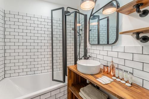 een badkamer met een wastafel, een douche en een bad bij La Plume in Marseille