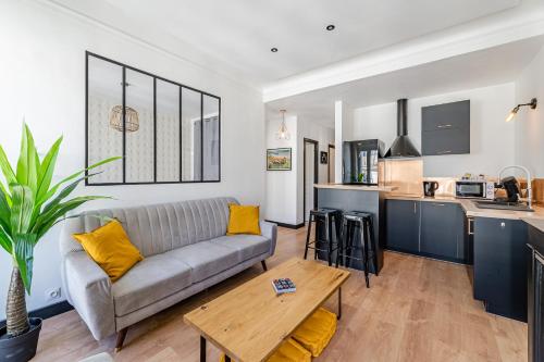 un salon avec un canapé et une cuisine dans l'établissement La Plume, à Marseille