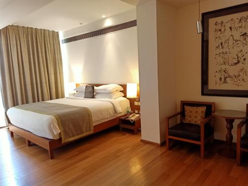 a hotel room with a bed and a chair at The Park Navi Mumbai in Navi Mumbai