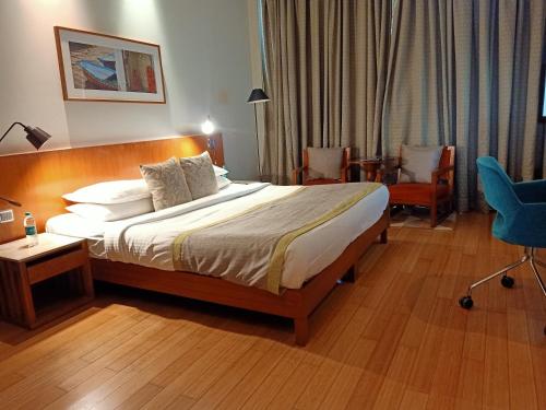 a hotel room with a bed and a chair at The Park Navi Mumbai in Navi Mumbai