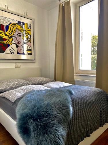a bedroom with a bed with a furry pillow on it at Chez Coco Apartment 2 Aachen in Aachen