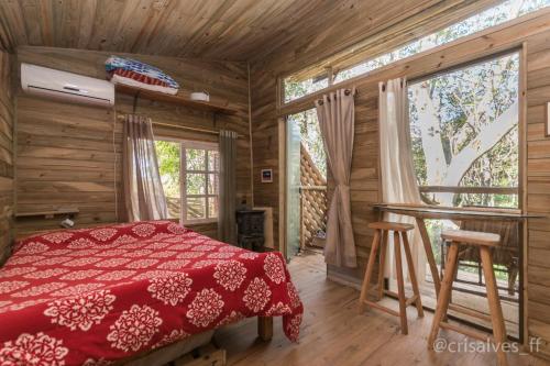 a bedroom with a red bed and a large window at Chalé Envidraçado no Itaimbezinho in Praia Grande
