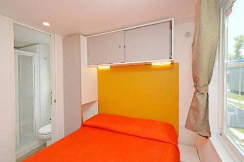 a small room with a bed and a window at San Francesco Camping Village in Desenzano del Garda