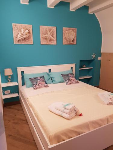 Un dormitorio azul con una cama con toallas. en Duomo Rooms Cefalù, en Cefalú