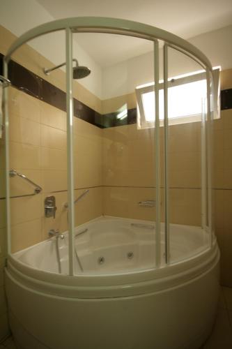 a bath tub in a bathroom with a shower at Liberty Hotel in Rethymno