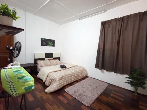 a bedroom with two beds and a bag in it at Sri Makmur Pontian Homestay in Pontian Besar