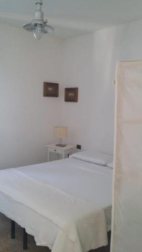 a white bed in a white room with a lamp at Marina di Corniglia Big Flat in 5 TERRE in Vernazza