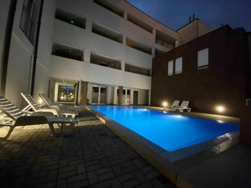 a large swimming pool in front of a building at Mifi Apartman Balatonlelle in Balatonlelle