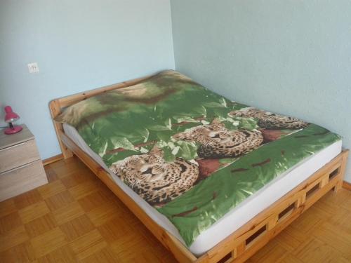 a bed with a green blanket on top of it at Anni Apartment in Tallinn