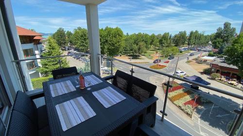 a balcony with a table and a view of a street at Mifi Apartman Balatonlelle in Balatonlelle