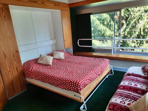 Schlafzimmer mit einem Bett und einem Fenster in der Unterkunft Vetrate sul bosco in Marilleva