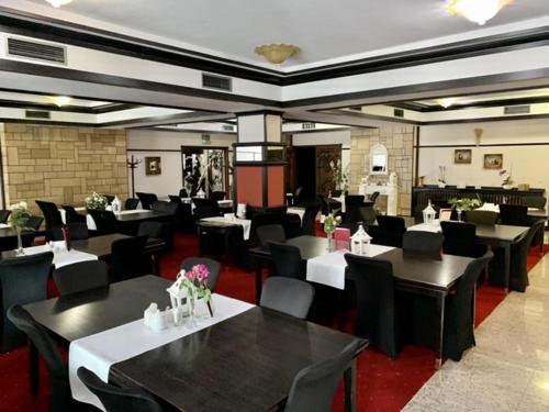 un restaurante con mesas negras y sillas negras en Nocowanie Restauracja Wenecka, en Kłobuck