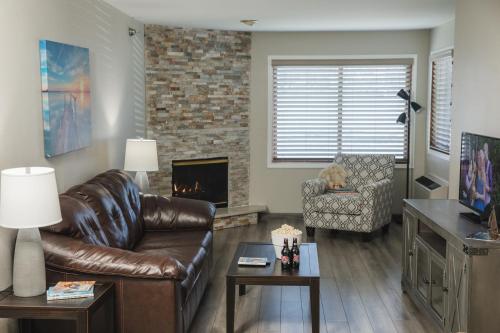 a living room with a leather couch and a fireplace at The Cove of Lake Geneva in Lake Geneva