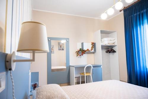 1 dormitorio con cama, escritorio y lámpara en affittacamere da Fiorella en San Miniato