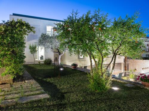 een tuin met twee bomen en een gebouw bij Hotel Colle Del Sole in Alberobello