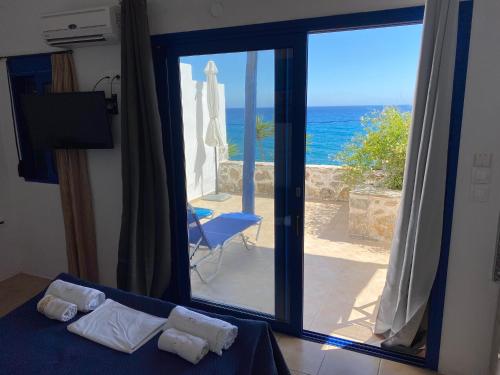 una camera da letto con una porta a vetri affacciata sull'oceano di Kionia Apartments a Kerames