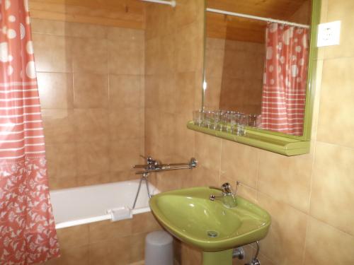 y baño con lavabo verde y bañera. en Apartma Podlogar Golica Triglav en Jesenice
