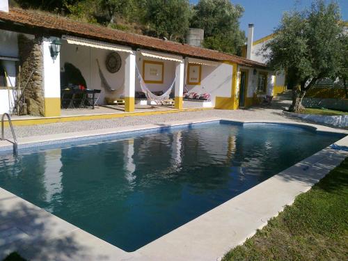 a swimming pool in front of a house at Casa do Pai Castelo de Bode in Serra