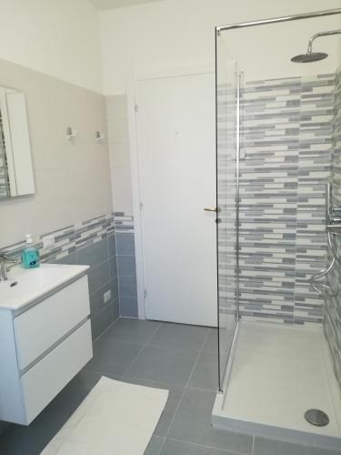 a bathroom with a glass shower and a sink at Casa di Roberta in Albiate
