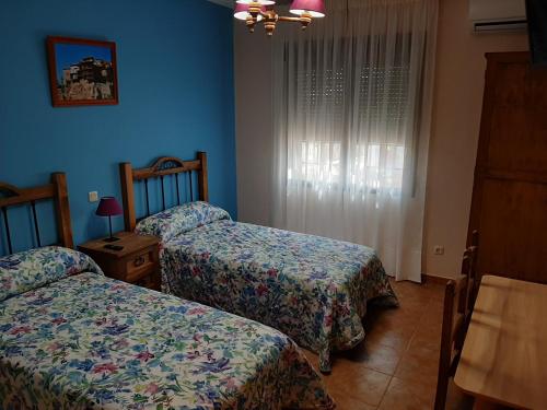 2 Betten in einem Zimmer mit blauen Wänden in der Unterkunft CASA RURAL LA CERCA in Madridejos