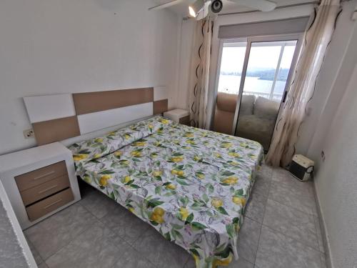 a bedroom with a bed with a floral bedspread at Apartment Levante in Benidorm