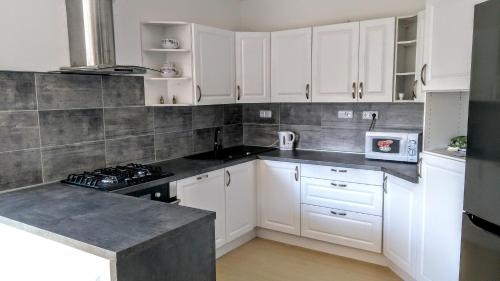 a kitchen with white cabinets and a stove top oven at Vila v Podkrušnohoří in Jirkov