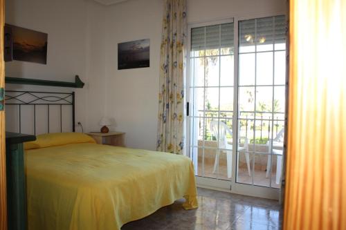 a bedroom with a bed and a sliding glass door at Estrella de Mar in Los Urrutias