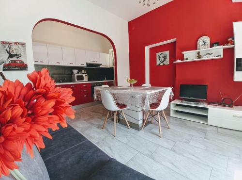 a kitchen with red walls and a table and chairs at Glorianita sweethome,centro, FREE parking,SELF CHECK- IN in Šibenik