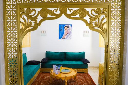 a living room with a green couch and a table at Dar El Jerbi in Mezraya