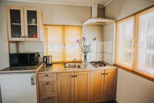 a kitchen with a sink and a counter with flowers at Guest House Baltās Dūjas in Saulkrasti