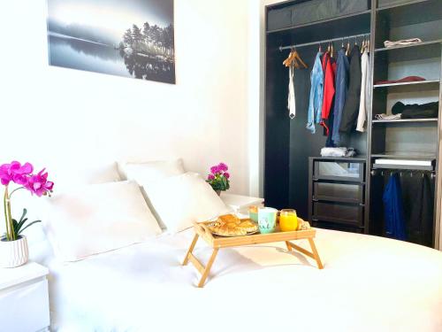 una camera da letto con un letto e un vassoio di cibo sopra di Oasis au Coeur de Ville a Le Plessis-Robinson