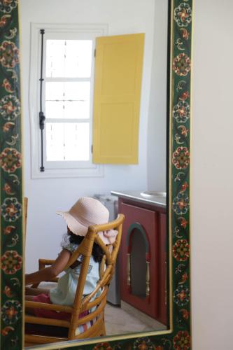 a little girl sitting in a chair in a mirror at Dar El Jerbi in Mezraya