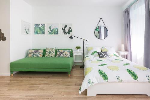 a bedroom with a green bed and a green couch at Cozy modern STUDIO GREEN APARTMENT in Old Town in Krakow