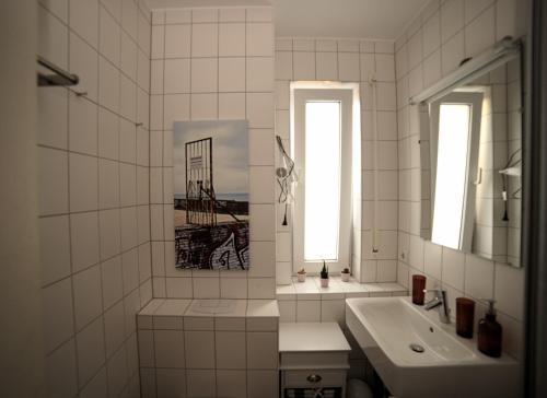 a white bathroom with a sink and a mirror at Schöne Ferienwohnung Breege in Breege