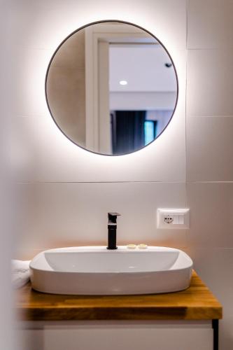 a bathroom with a white sink and a mirror at Rea Boutique Hotel in Himare