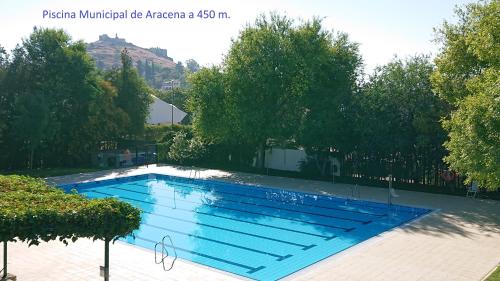 a swimming pool in a yard with trees at Apartamentos Turísticos Santa Marina in Aracena