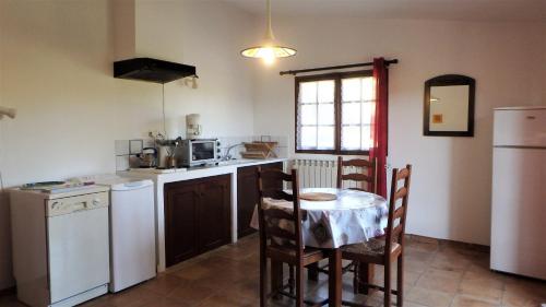 - une cuisine avec une table, une table et des chaises dans l'établissement Domaine Saint-Jaume gîte Cinsault, à Barjols