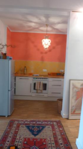 a kitchen with an orange wall and a stove at Vorderer Westen Kassel in Kassel